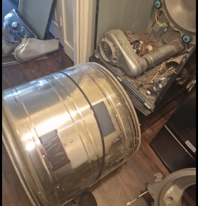 Dryer drum pulled out of the cabinet for drive belt replacement
