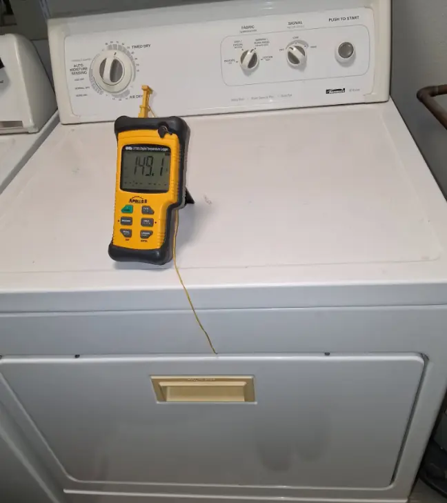 Digital meter on top of an electric dryer during a heat sensor test